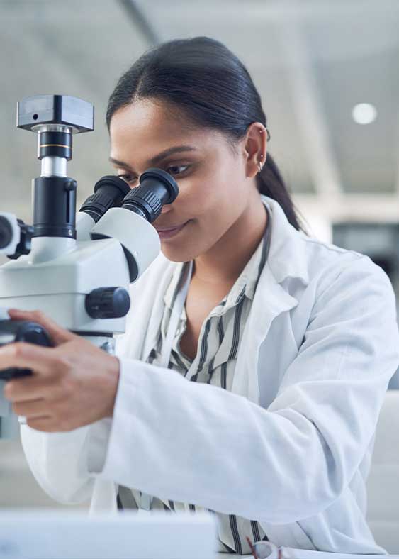Clinical Laboratory Scientist looking into a microscope.